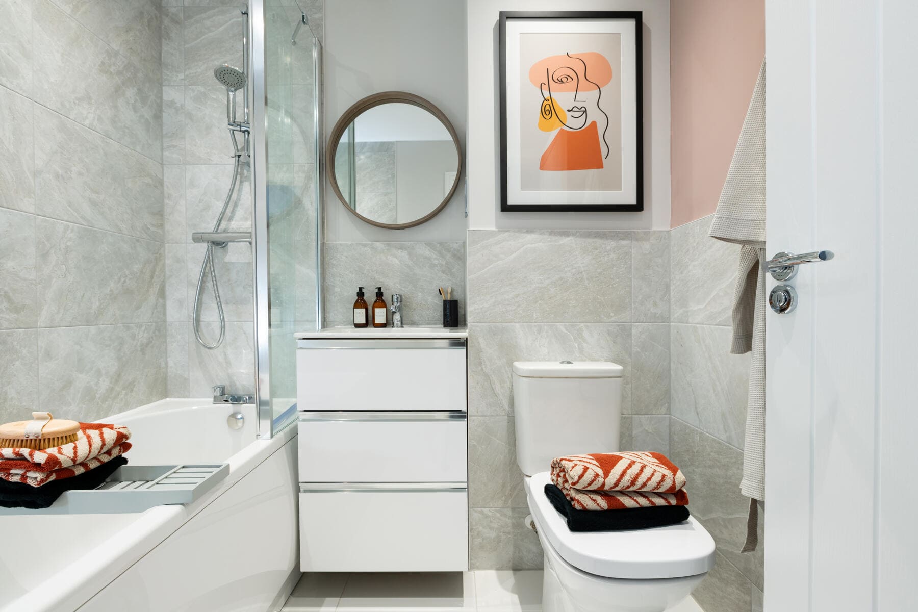 Toilet, sink and shower over bath