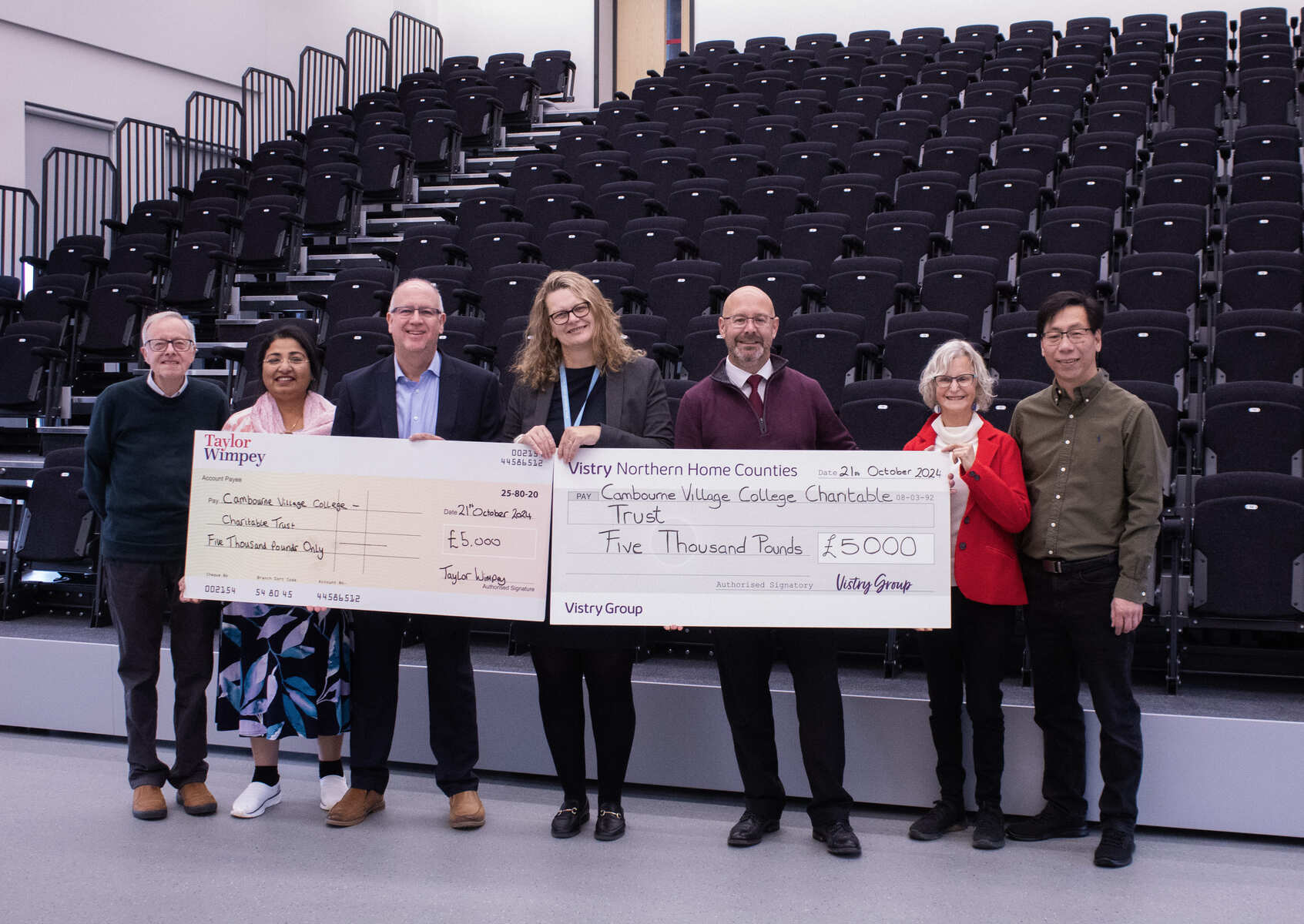 People holding cheques in theatre