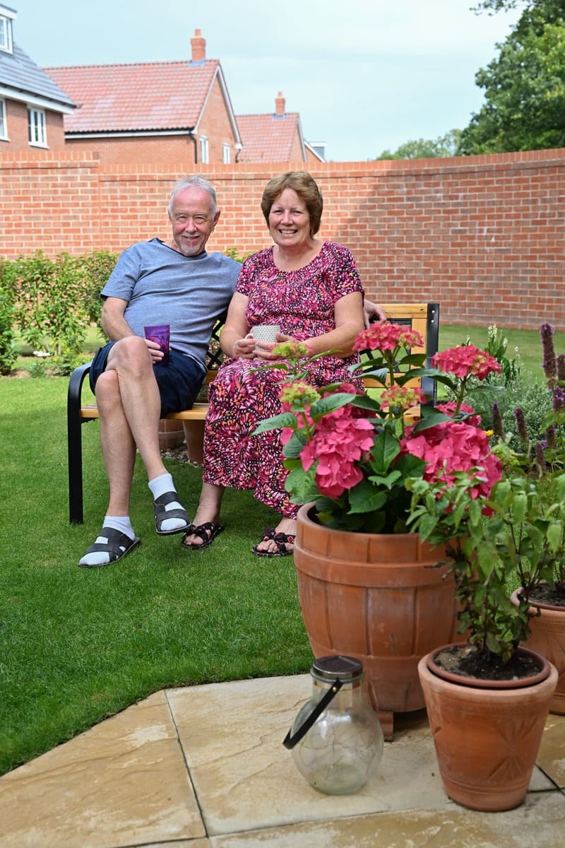 Man and wife on bench in garden