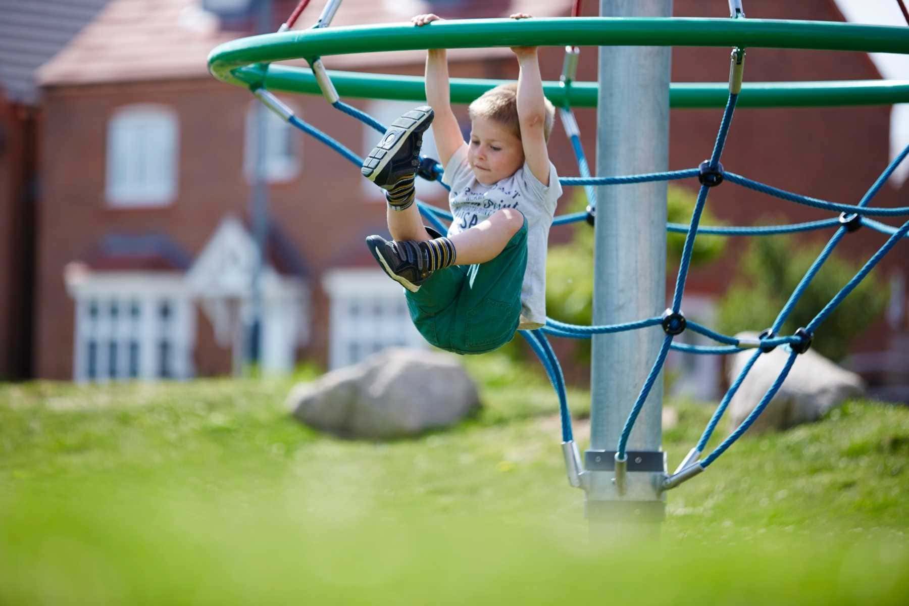 Boy playing on climbing frame