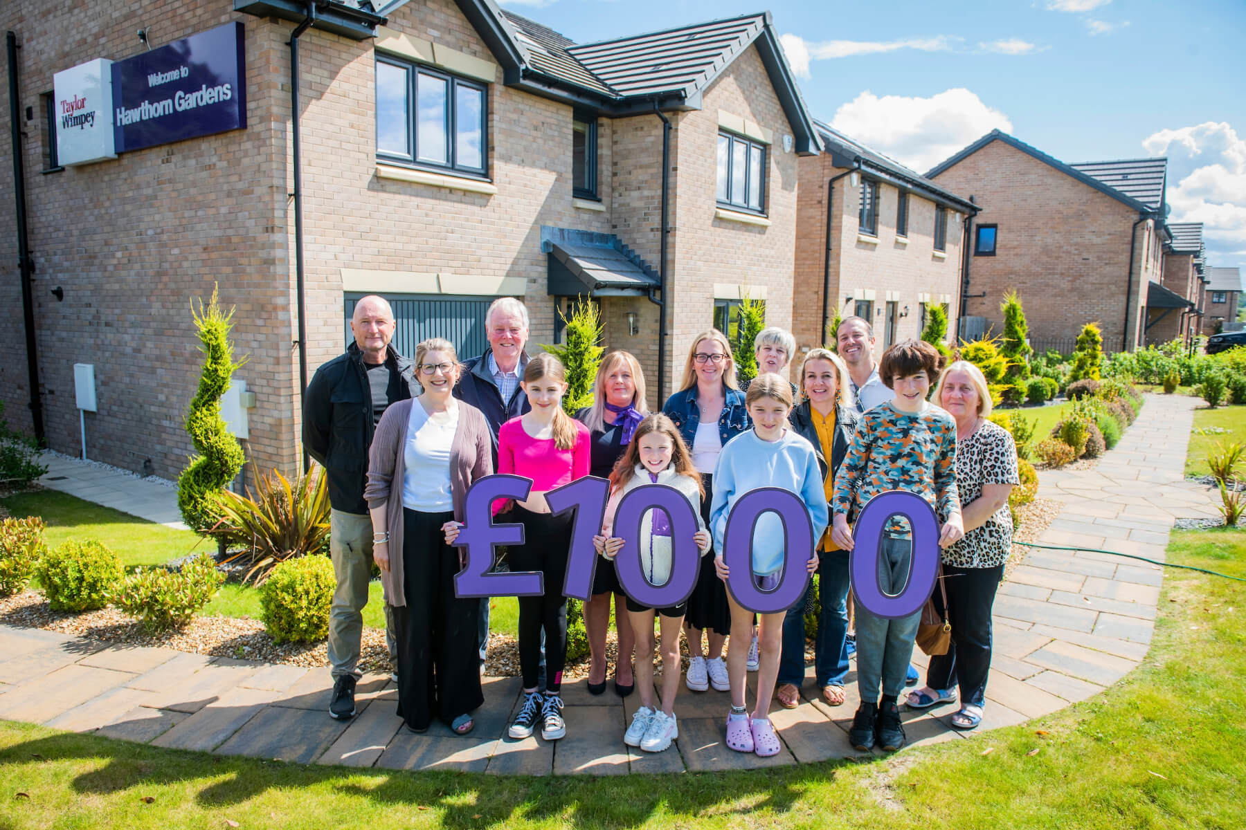 Representatives from Queensferry Community Association, City of Edinburgh Council Lifelong Learning Services, Queensferry & District Community Council join local Taylor Wimpey East Scotland sales executive Helen Allenby at Hawthorn Gardens in South Queensferry.  They are also joined by some of the young people hoping to take part in the Summer Fun Programme.