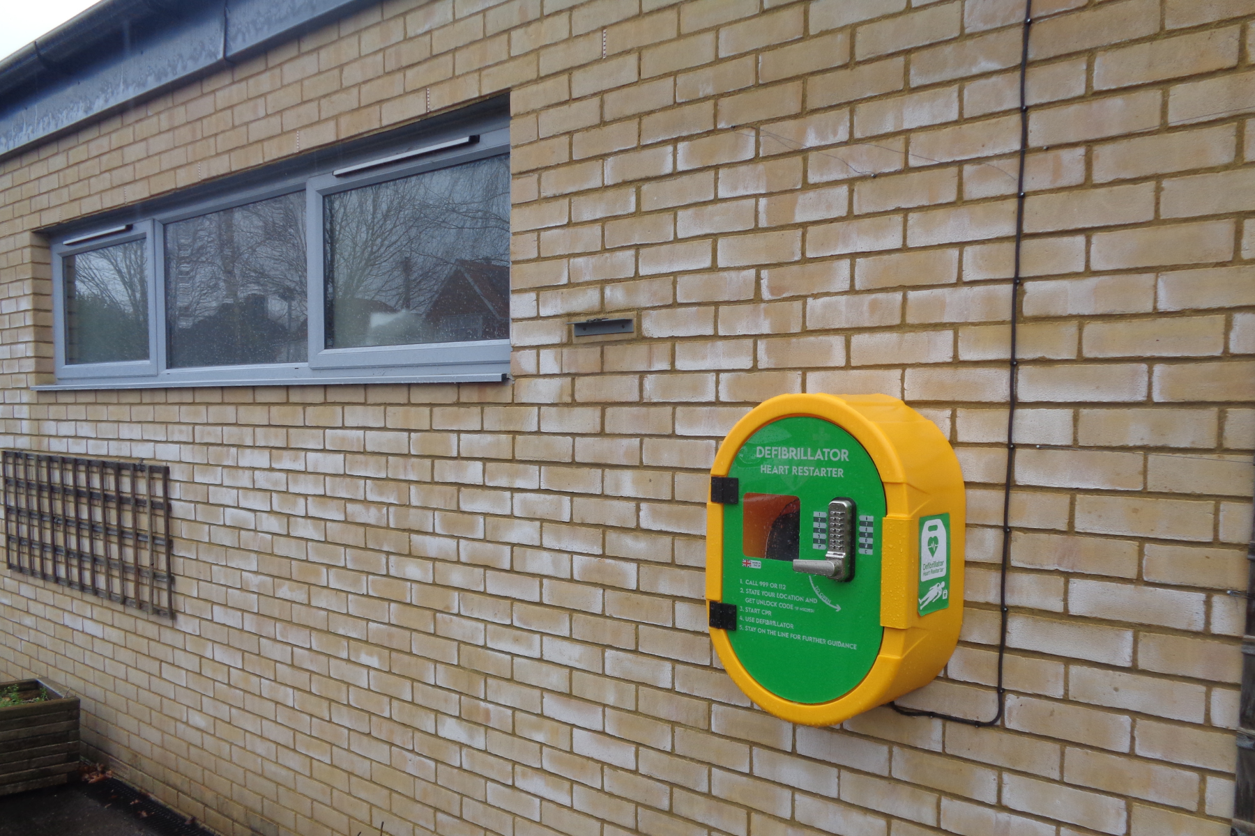 The defibrillator at Hassocks Infant School installed in the new cabinet that we donated