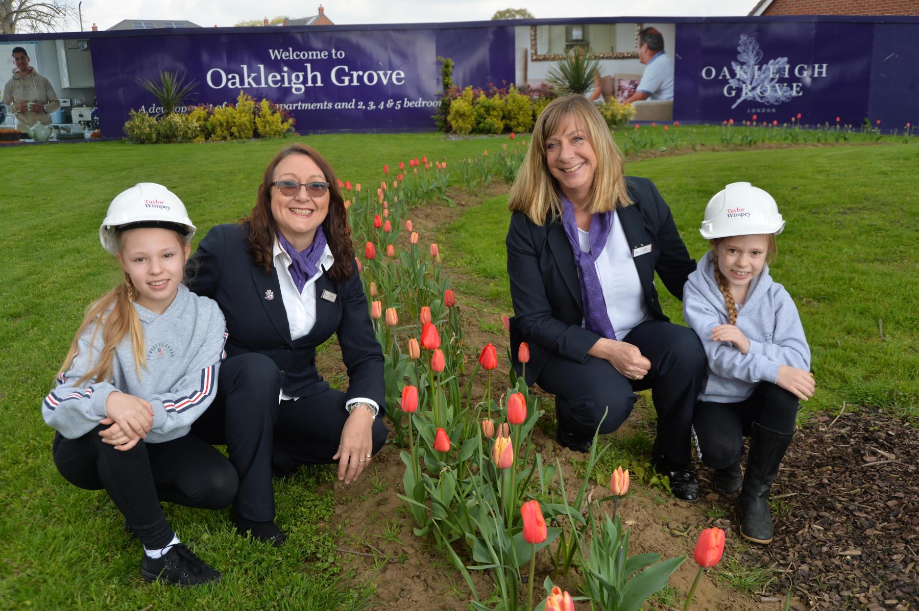 Sales Executives with children smiling next to flowers