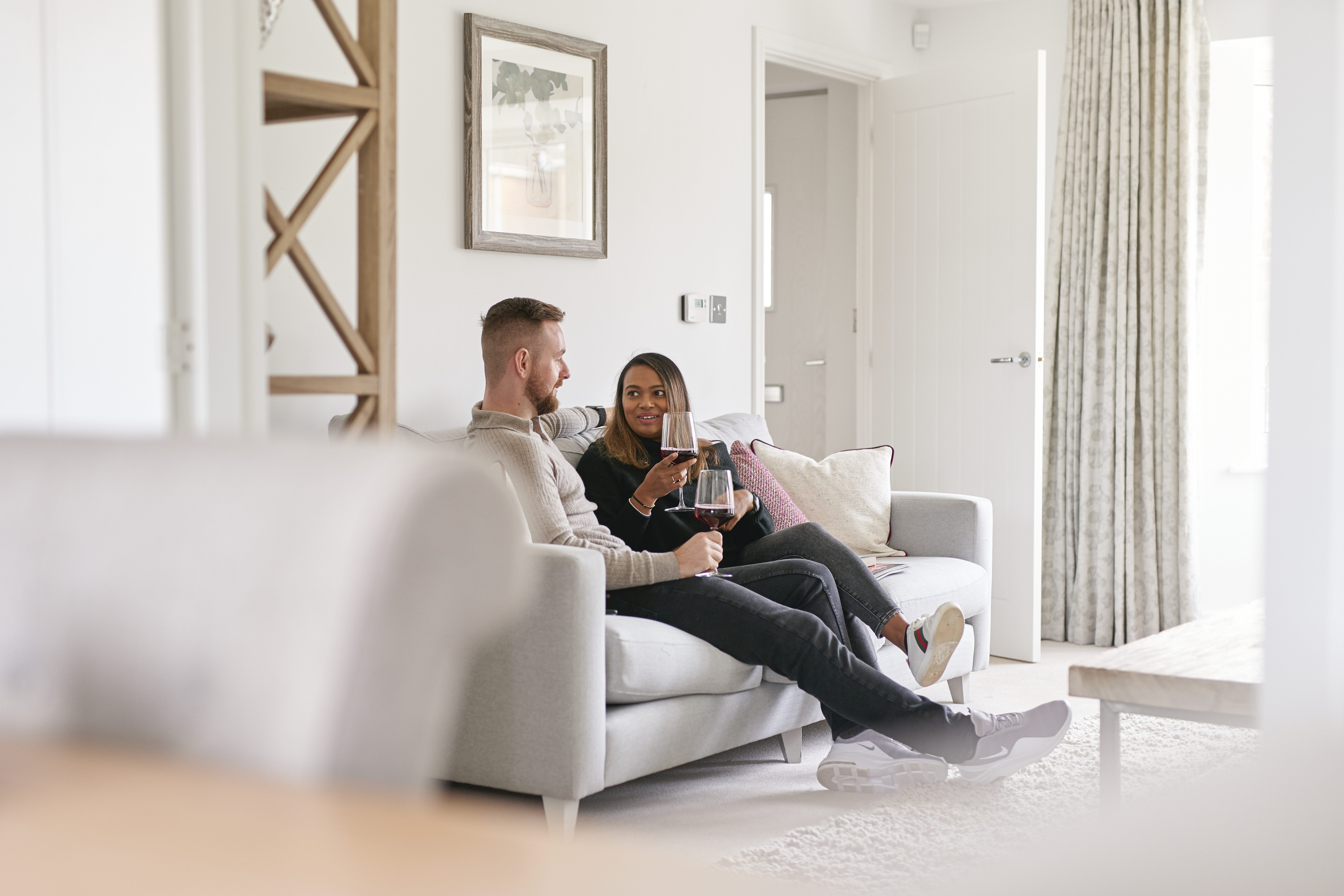 Couple in new Taylor Wimpey home lounge