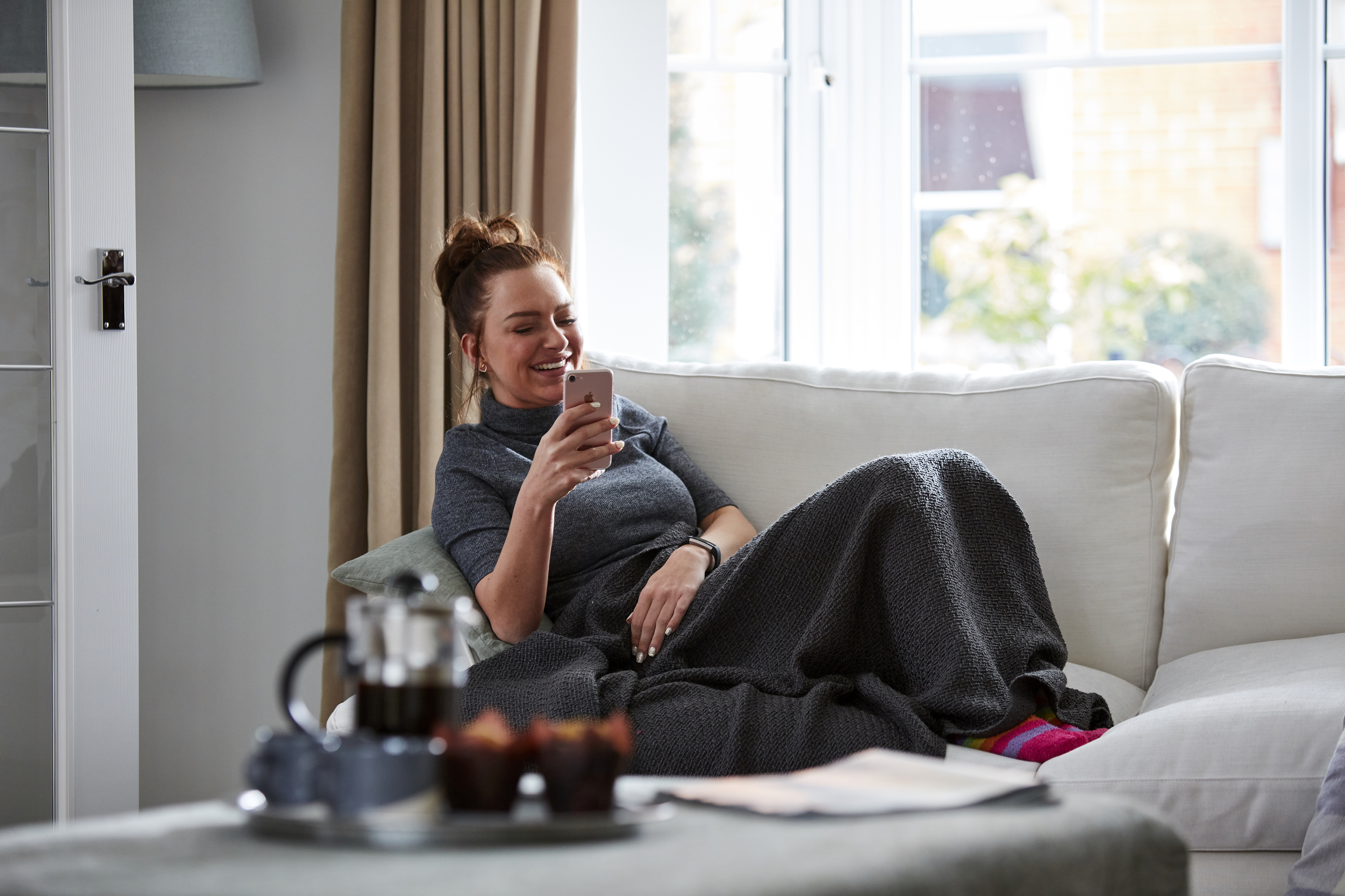 Lady in new Taylor Wimpey home lounge on the phone