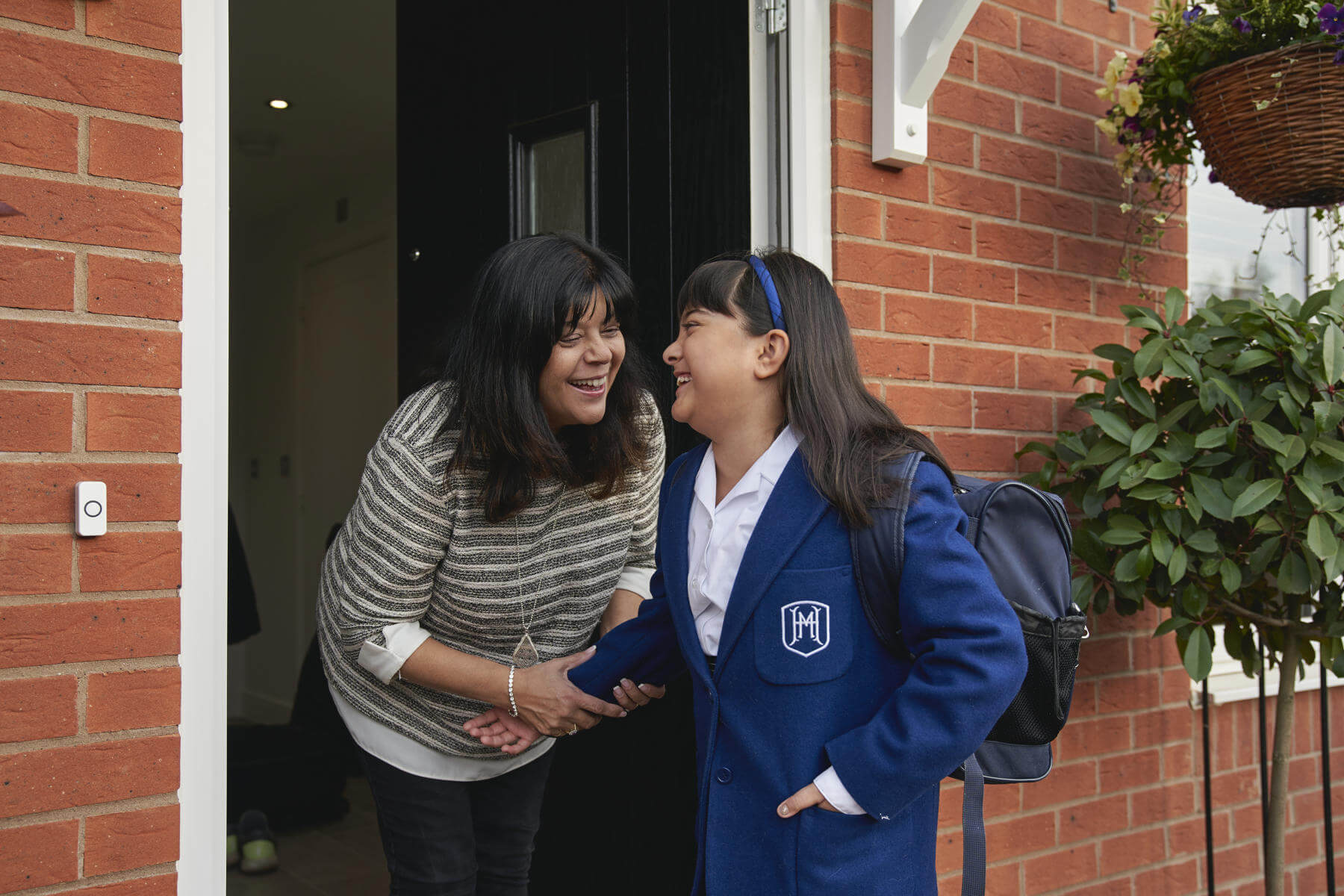 Mother and daughter outside their new home