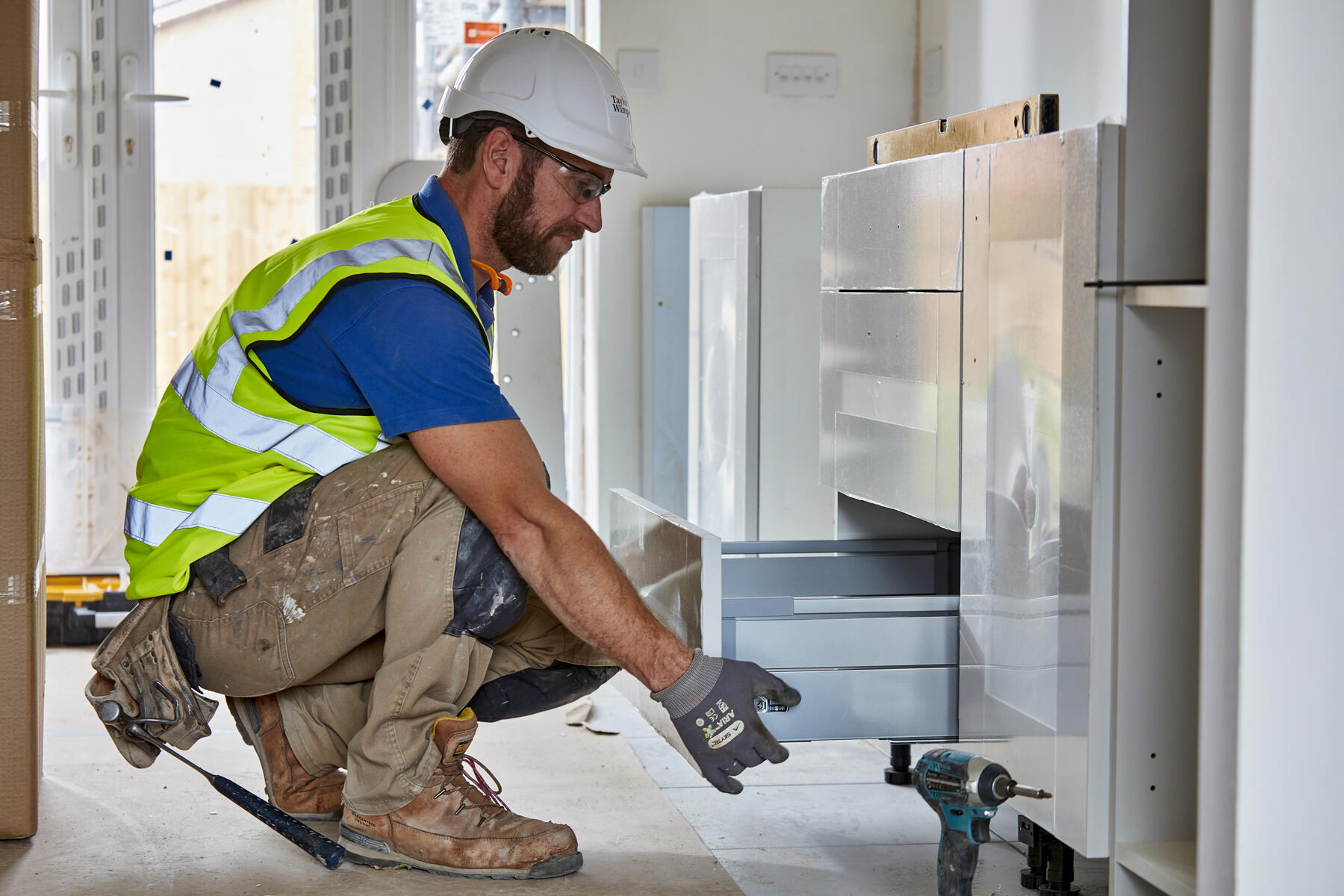 Staff member fitting kitchen