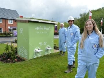 Bee house with workers in blue overalls