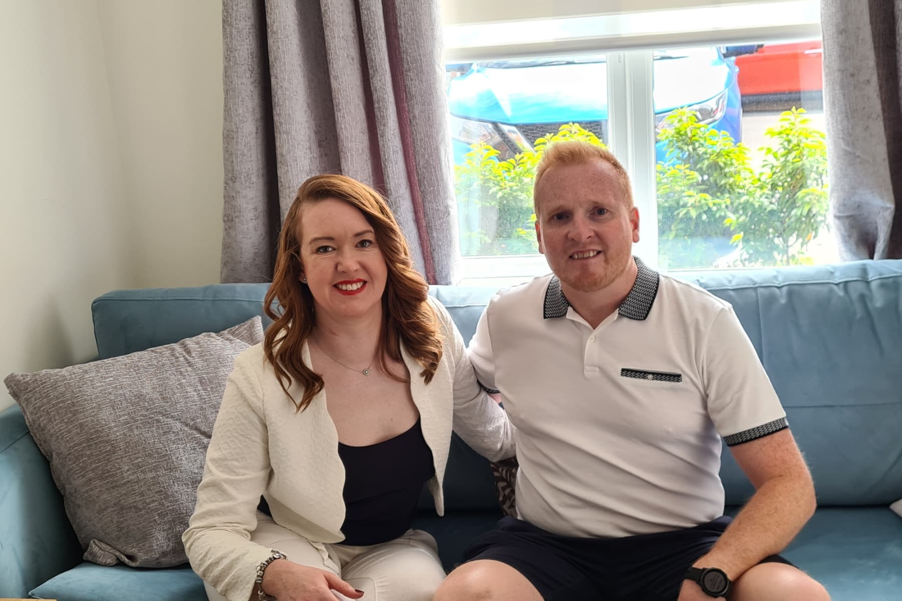 Laura and her partner Paul sitting on the sofa