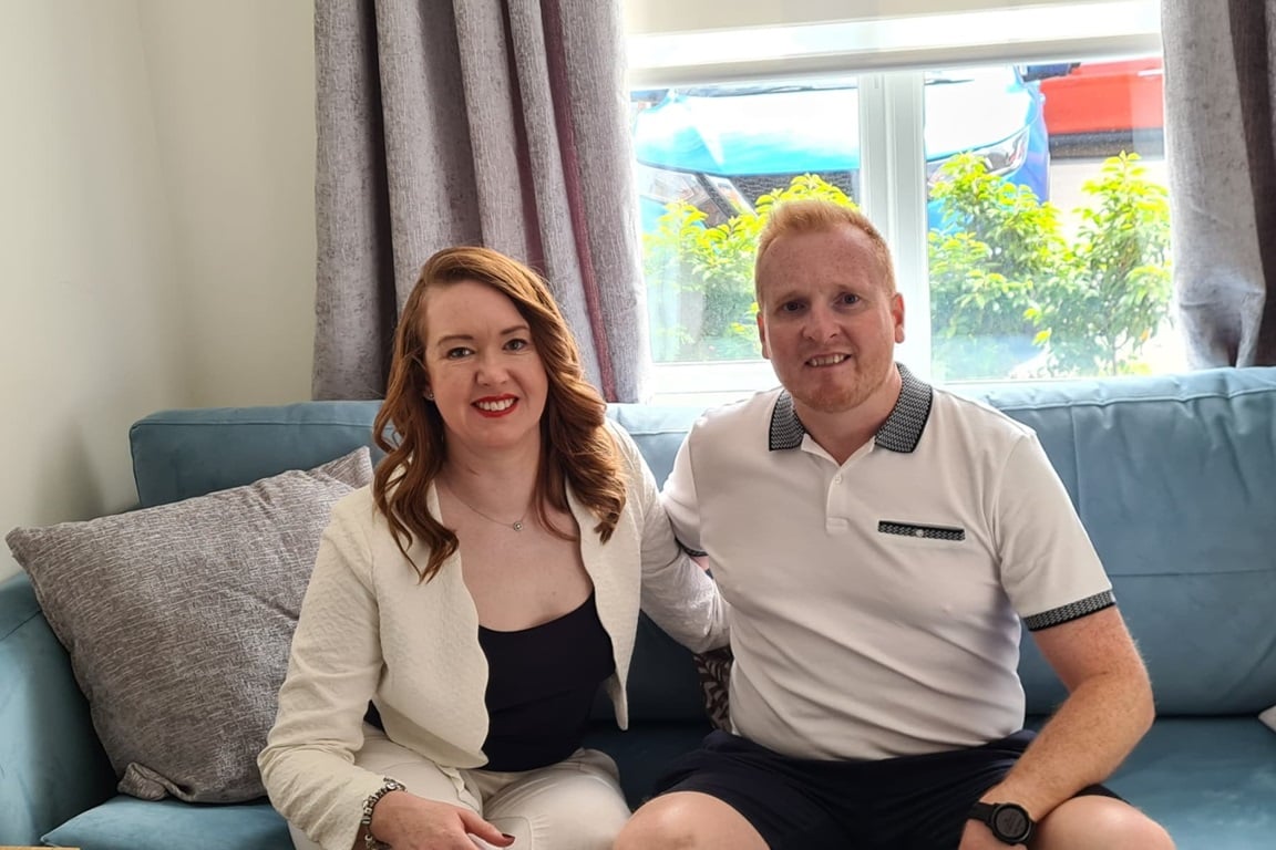 Laura and her partner Paul sitting on the sofa