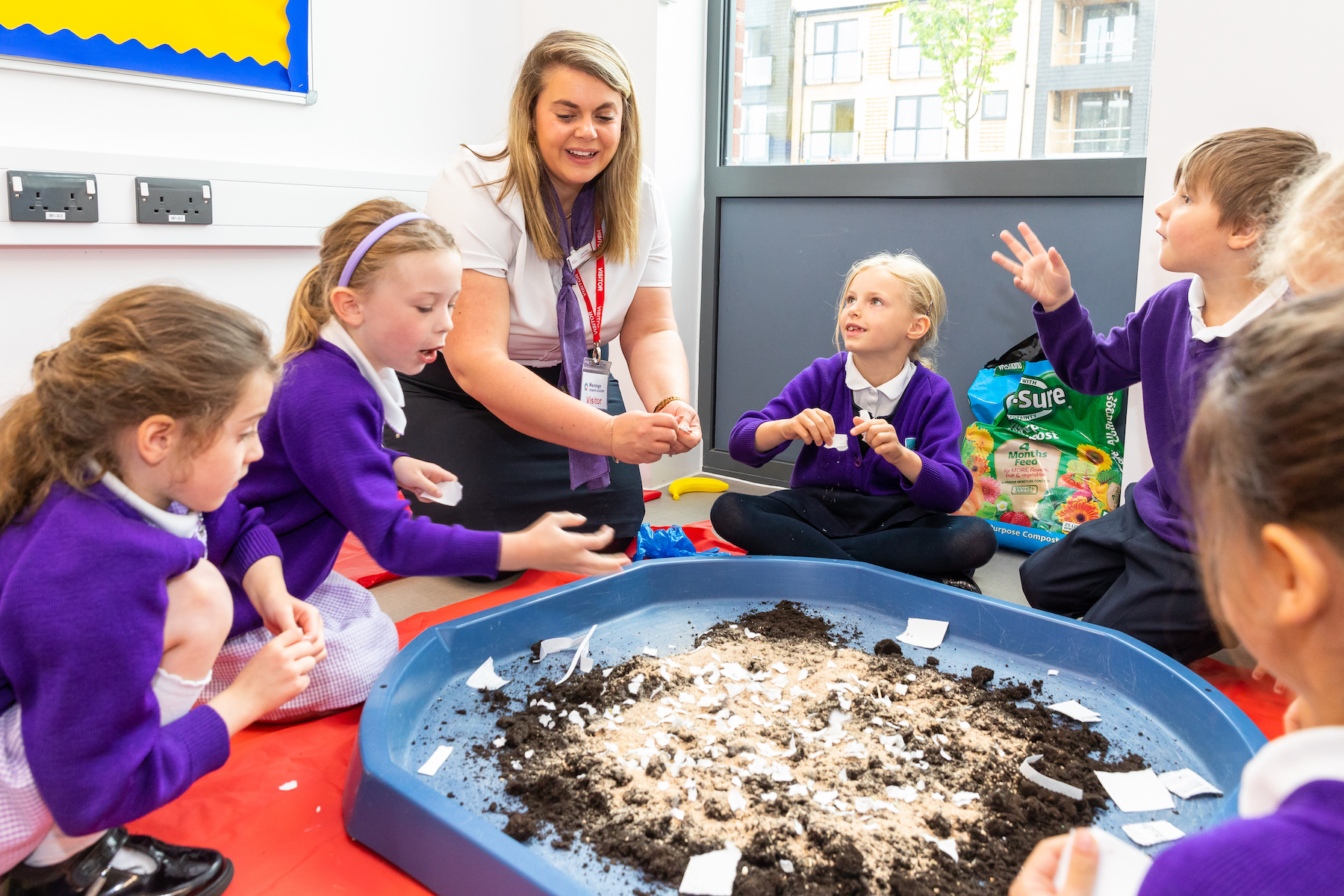 Taylor Wimpey representative and school children doing a bee related activity