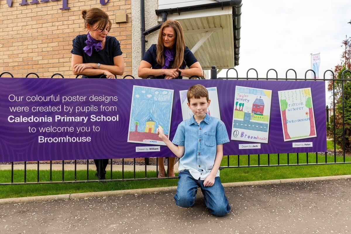Child in front of banner at Taylor Wimpey in Broomhouse.
