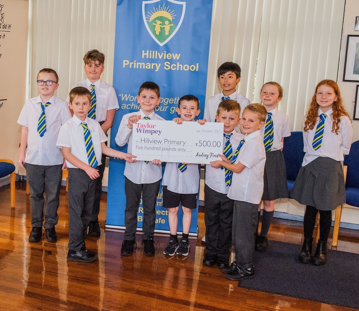 Group of school children in Barrhead receiving a cheque from Taylor Wimpey.