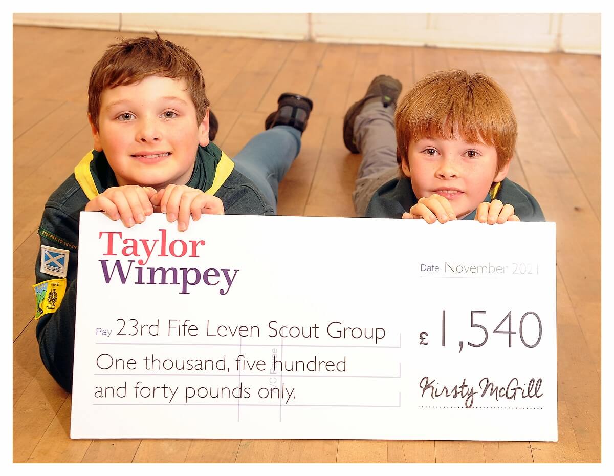Young scouts with a donation cheque from Taylor Wimpey.