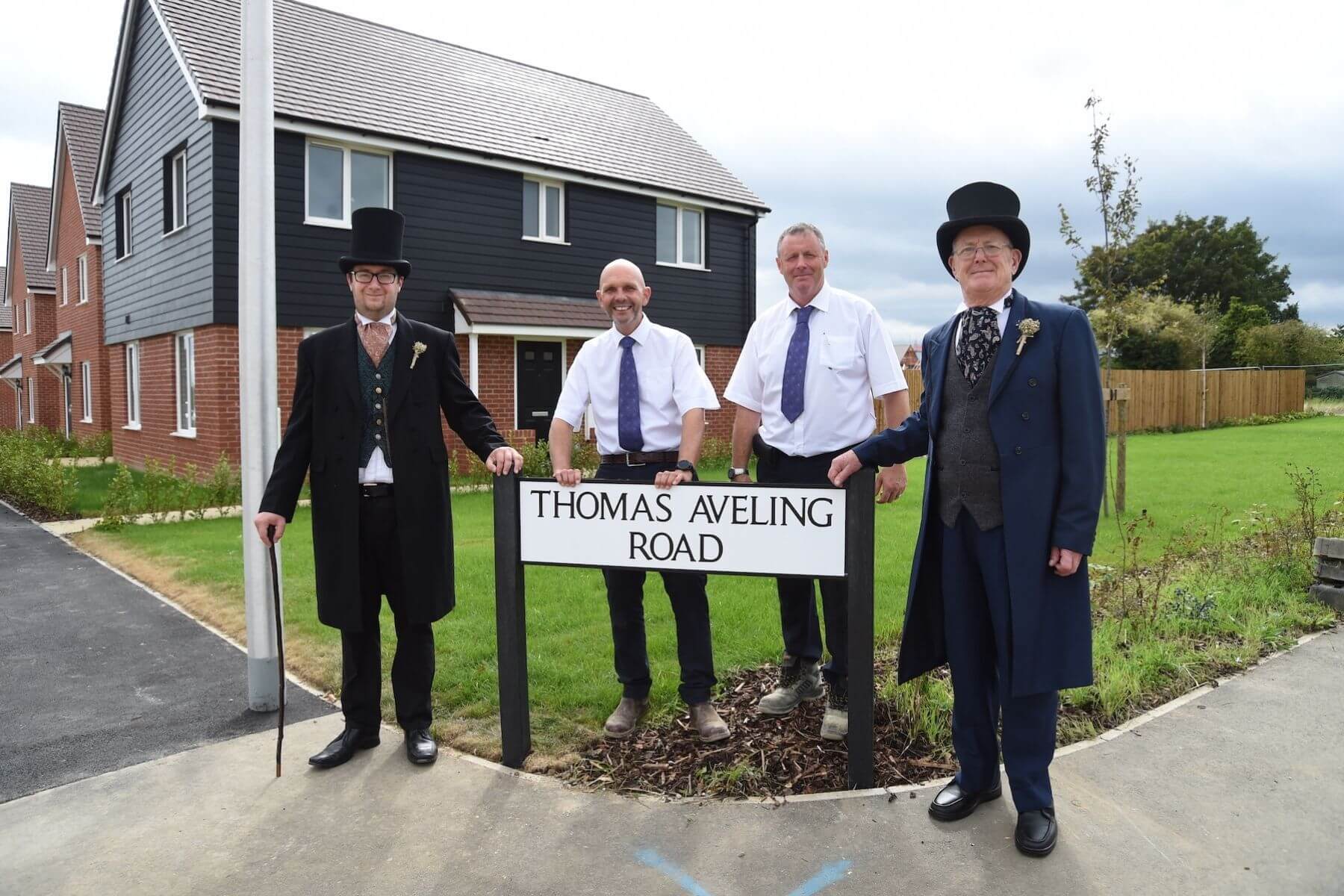 People in Victorian dress next to road sign