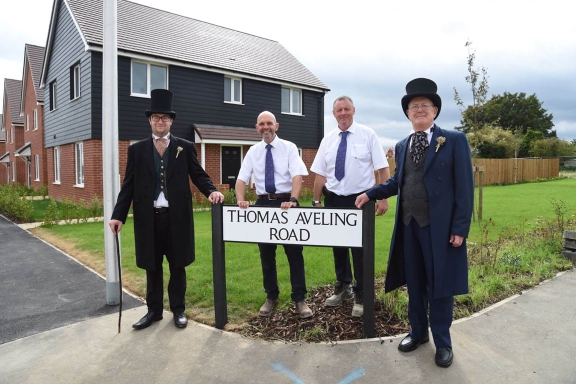 People in Victorian dress next to road sign
