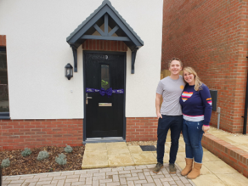 Couple outside new home