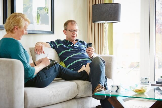 Family sat on sofa using mobile