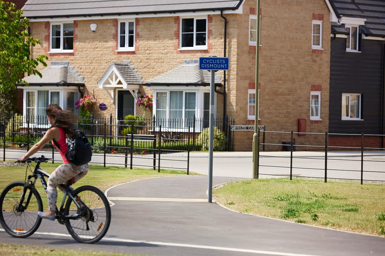 Person cycling by houses