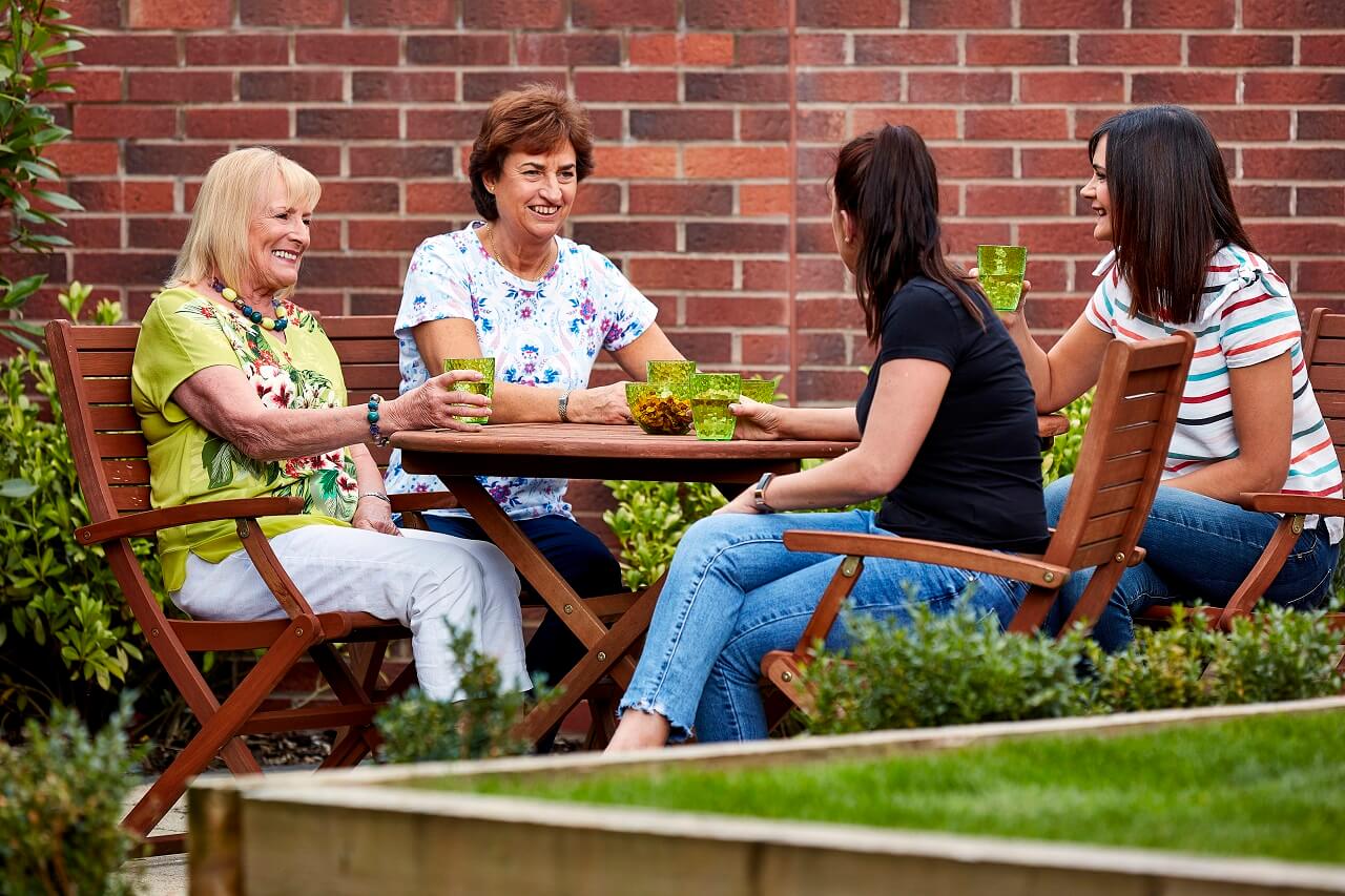 Friends sat at a table in a garden
