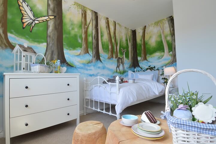 Child's bedroom with wilderness scene on wall