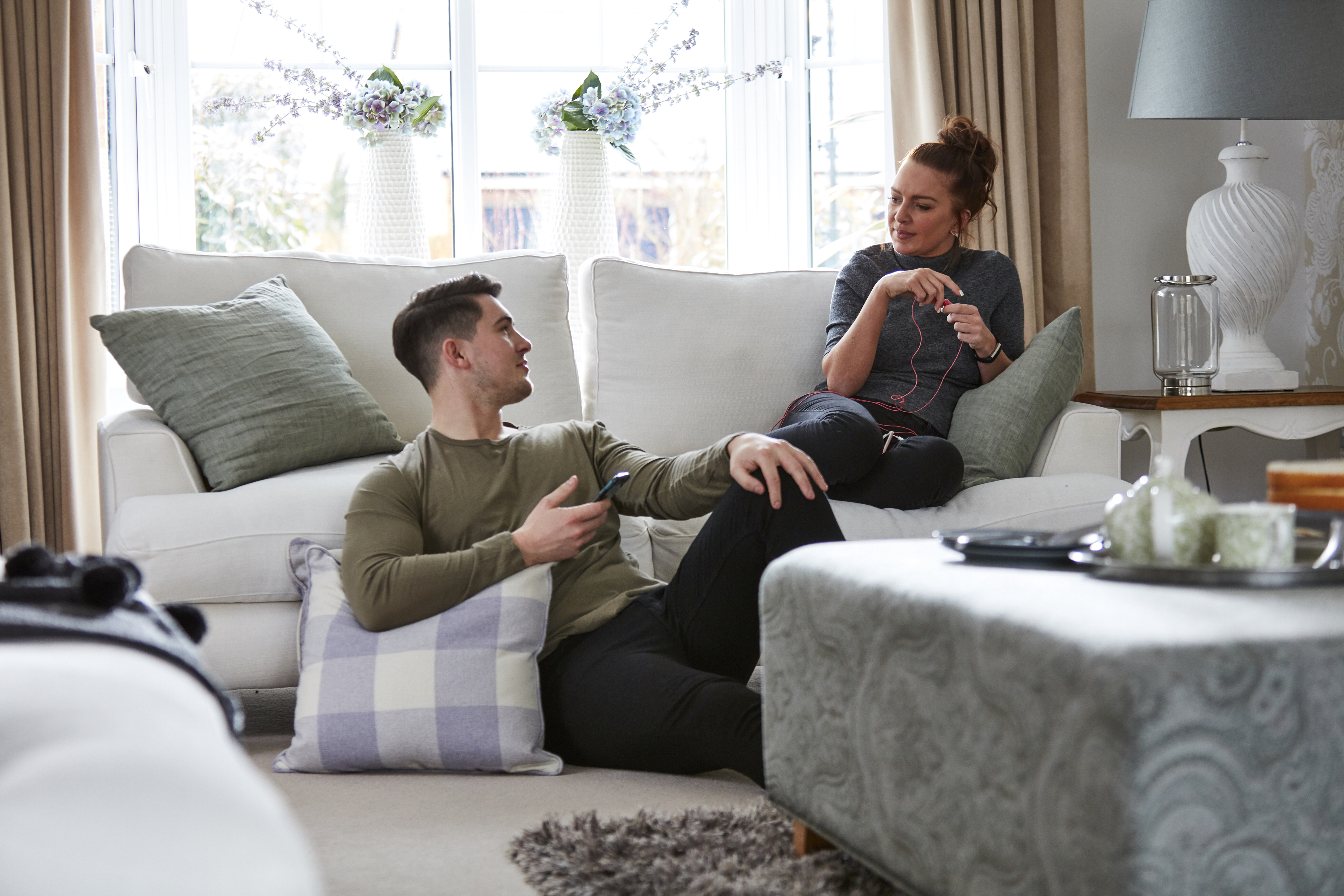 Couple in new Taylor Wimpey home lounge talking