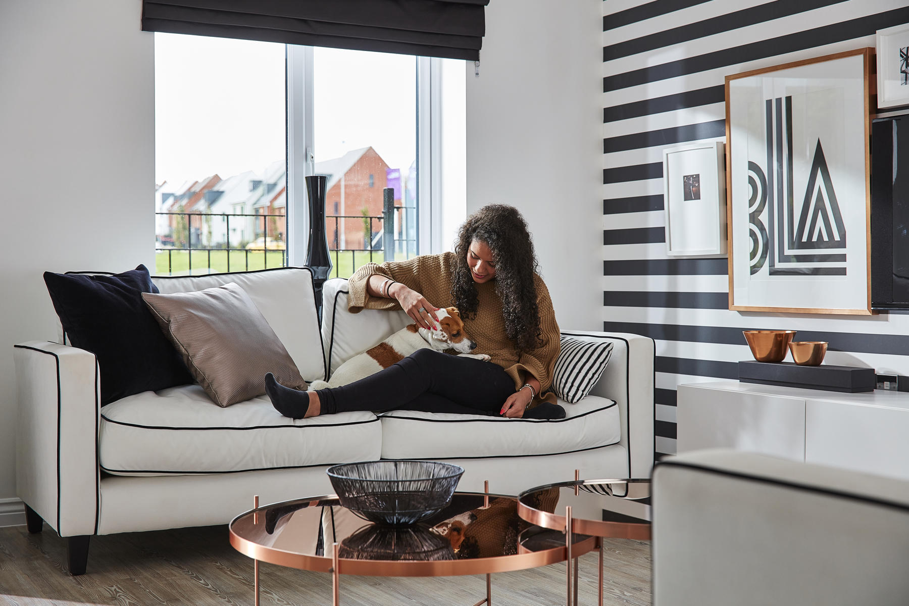 Girl sitting on sofa with dog looking happy