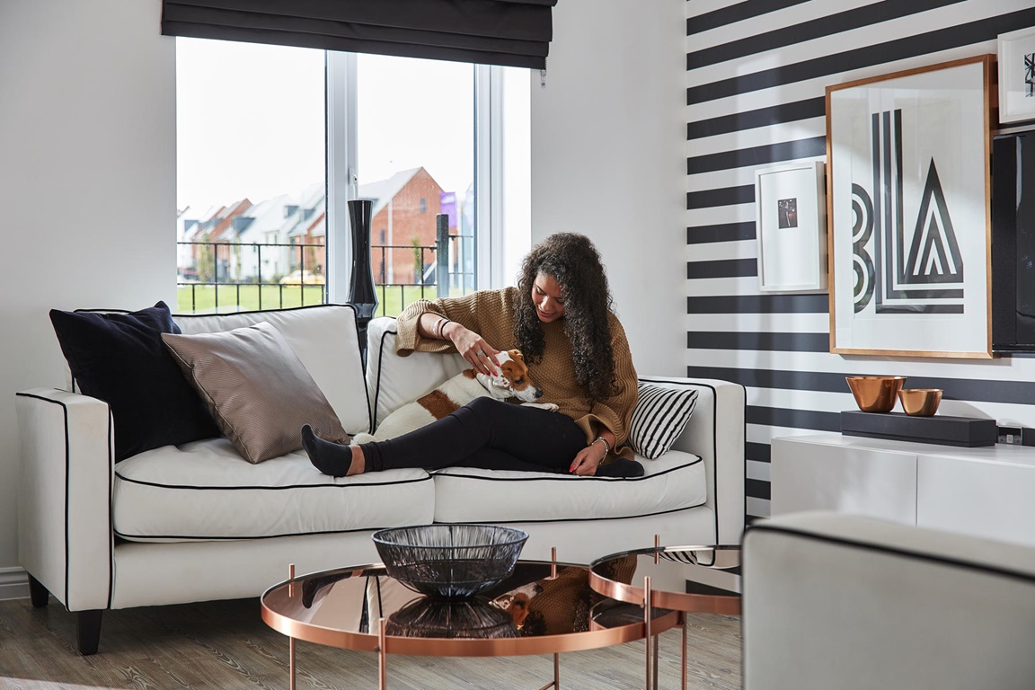 Girl sitting on sofa with dog looking happy