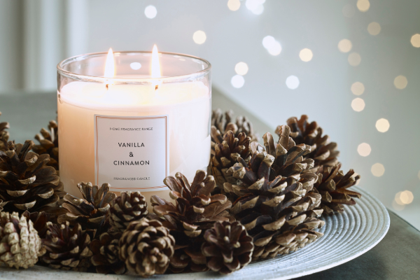 Candle surrounded by pinecones 