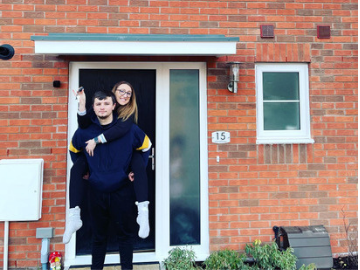 Couple stood by front door of new home