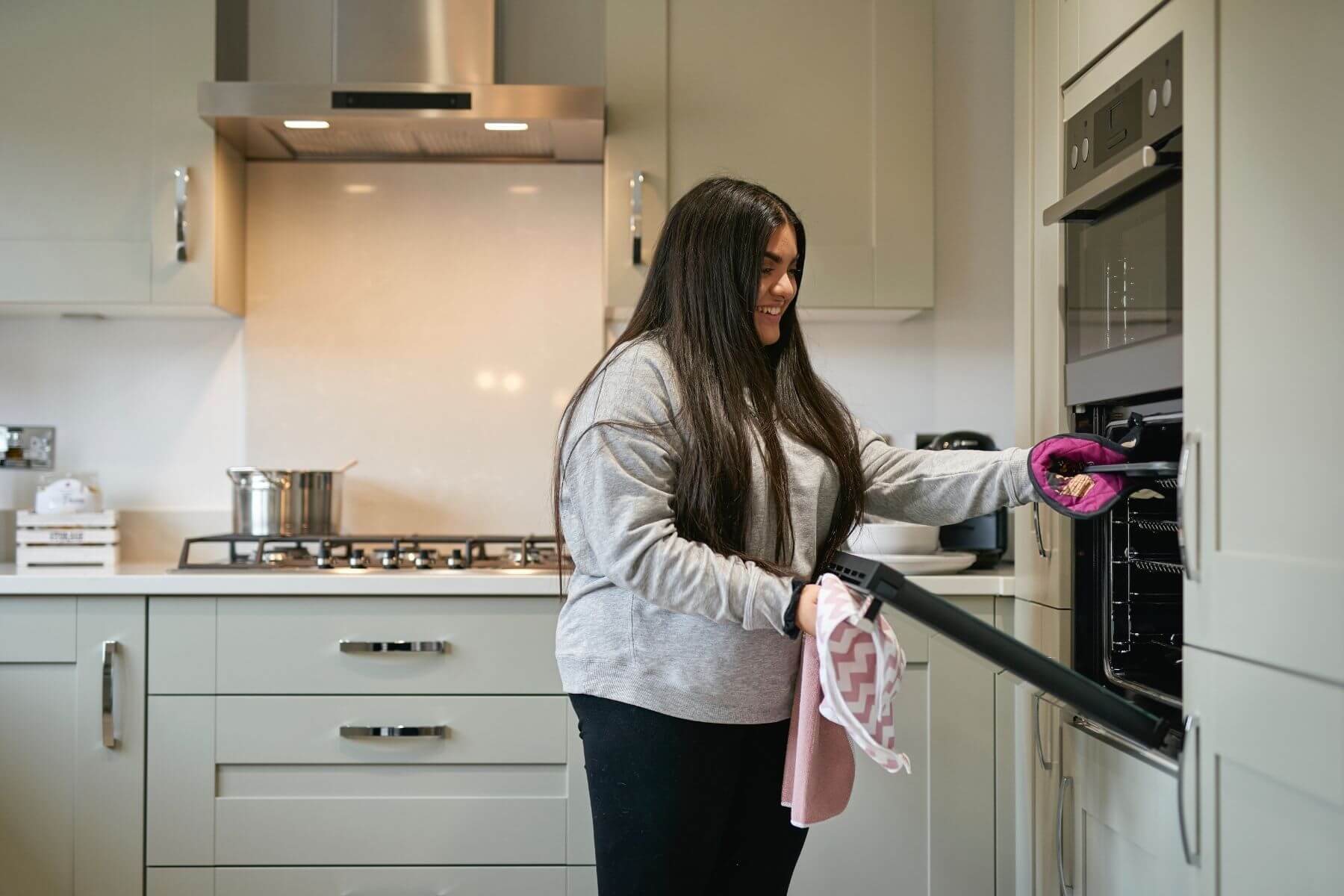 Girl getting food out of oven