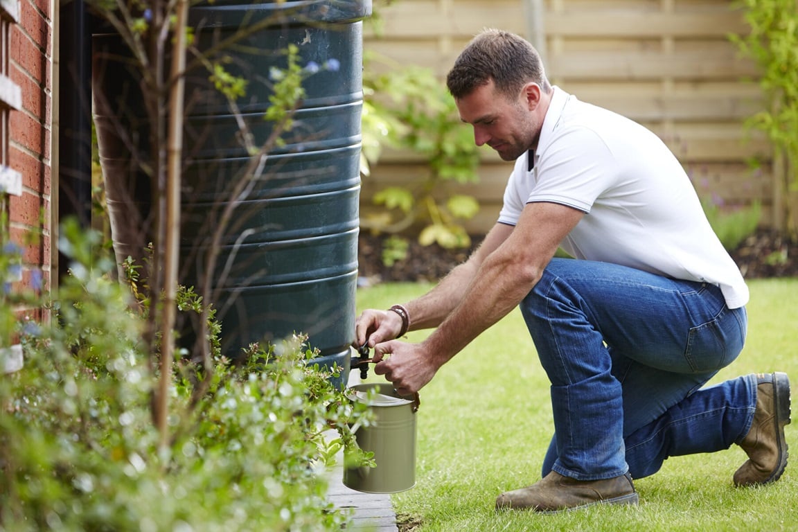 Man filling water from water butt