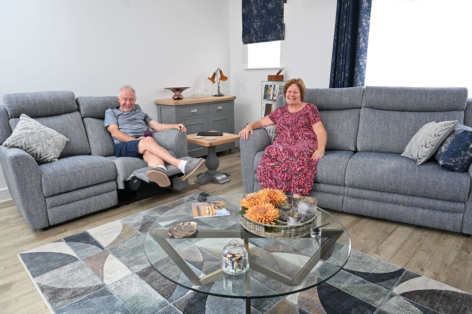 Couple sat on sofas in lounge