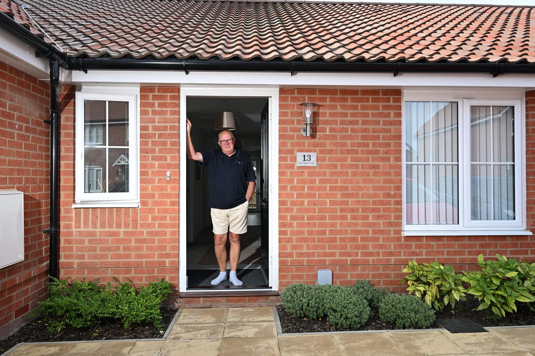 Man stood in front door of house