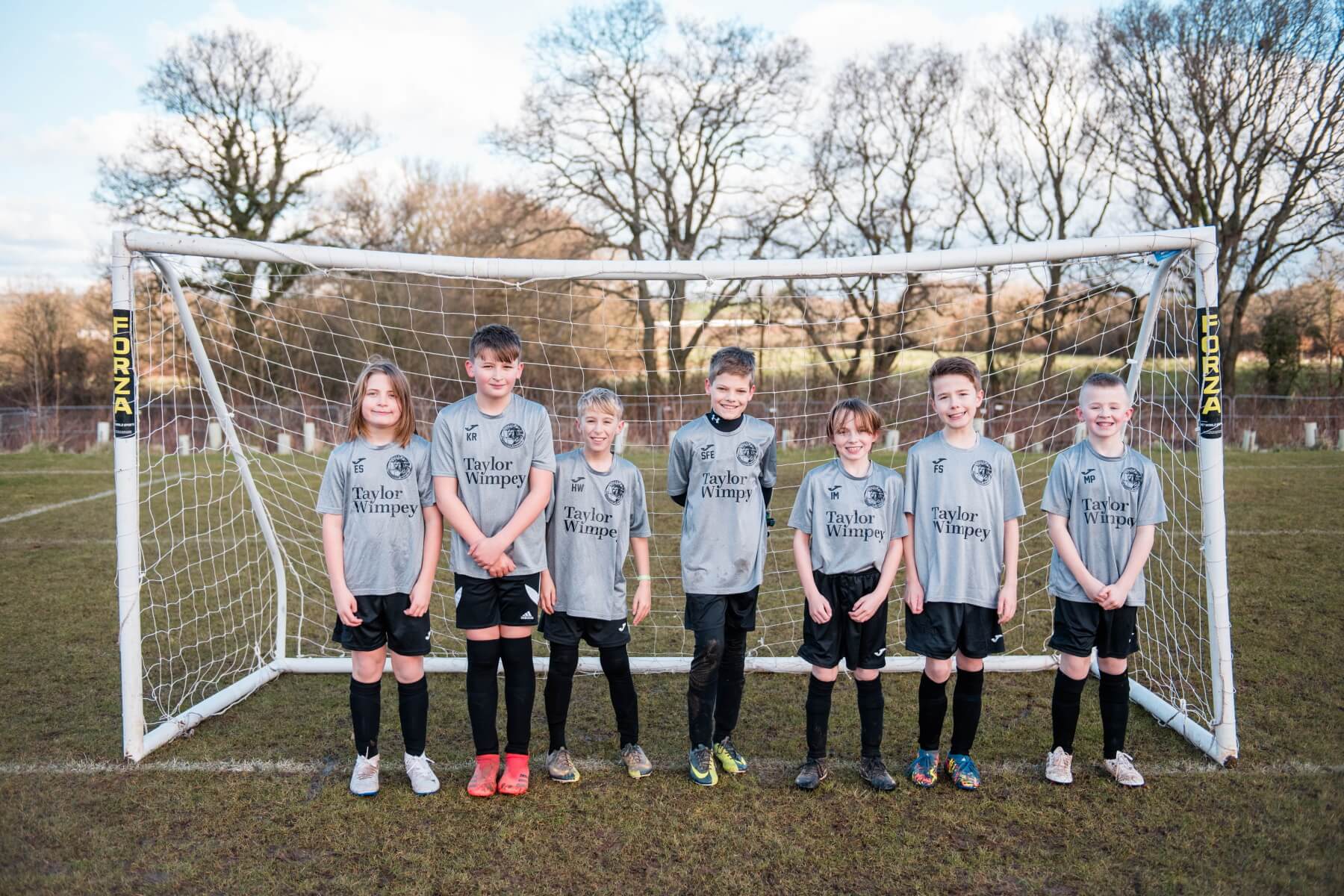 Cranbrook United under 9s posing in front of a goal in their kit