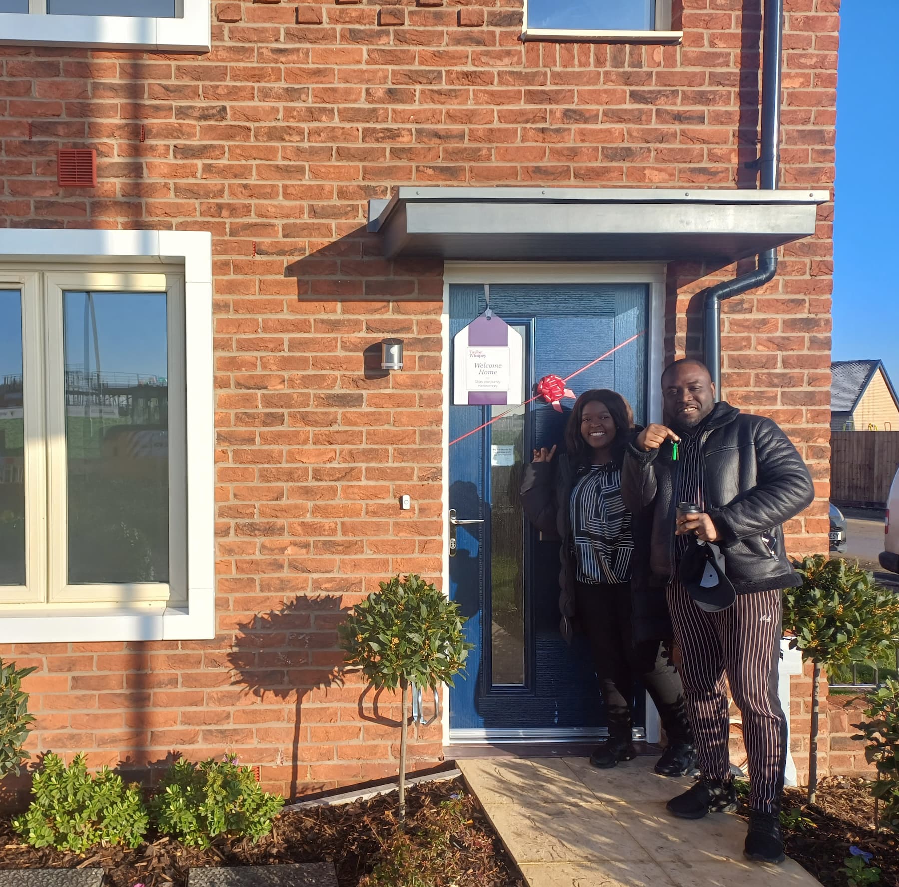 First customers with keys outside their new home
