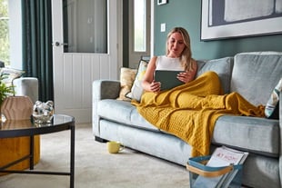 Customer sat on sofa with tablet