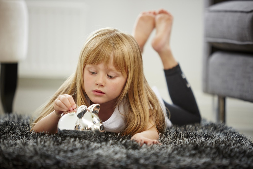 Young girl saving money in a moneybox