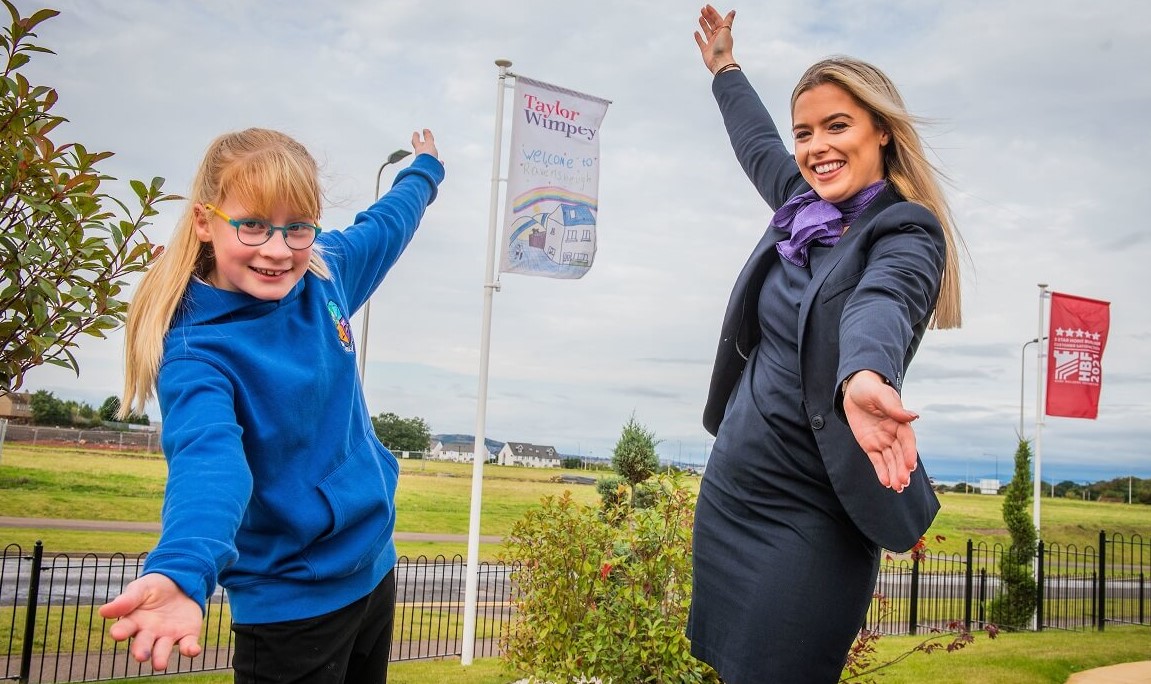 Little girl with winning flag design at Taylor Wimpey's development in Wallyford.