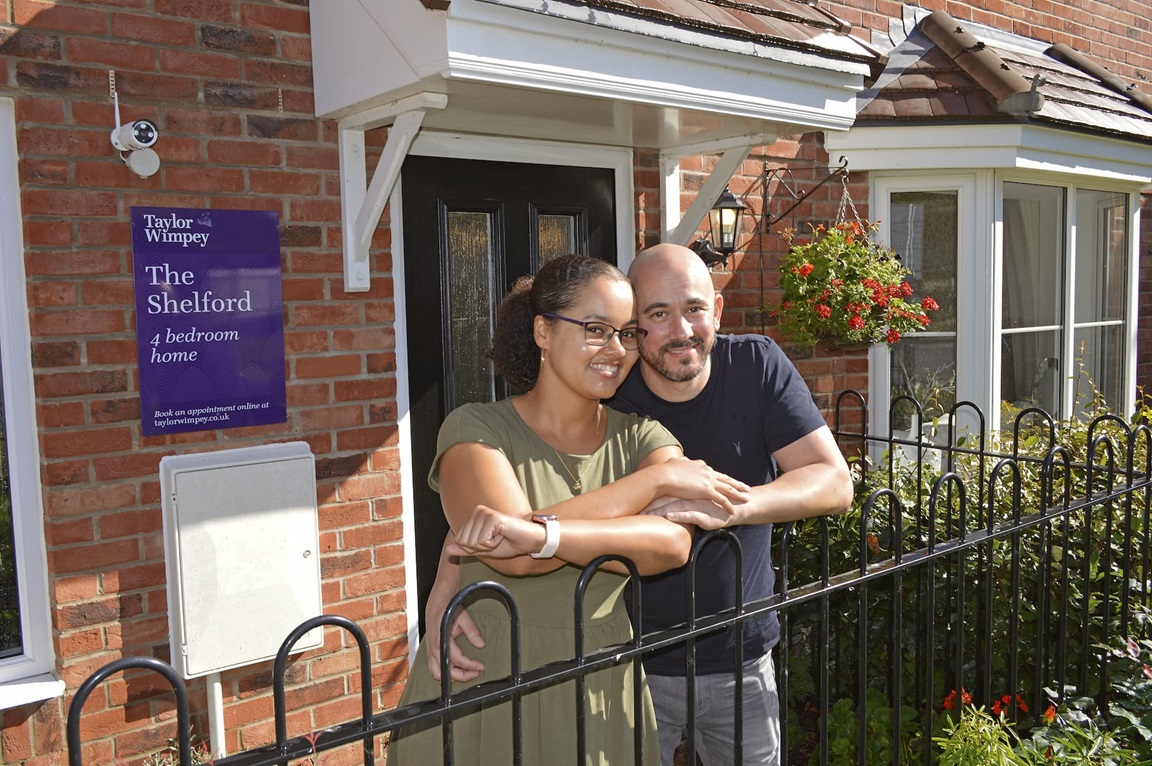 Couple standing outside new home