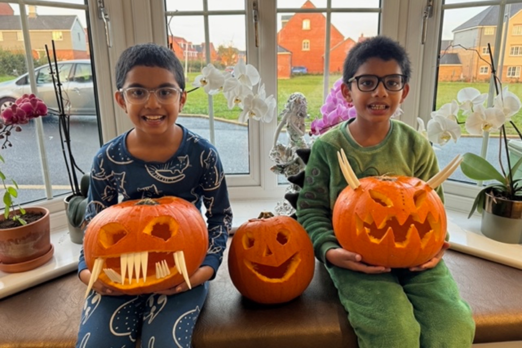Children holding their finished pumpkins in their Taylor Wimpey home