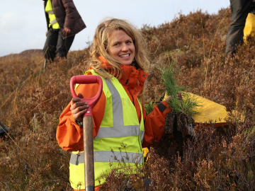 Blonde lady with shovel and plant