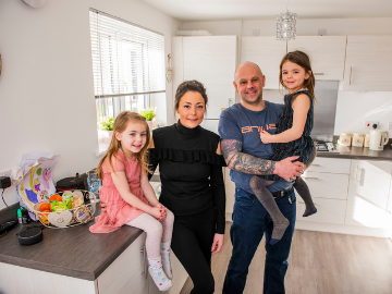 Family of four standing in new home