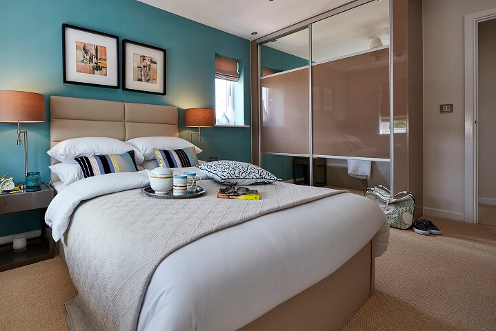 Bedroom with blue walls and mirrored closets