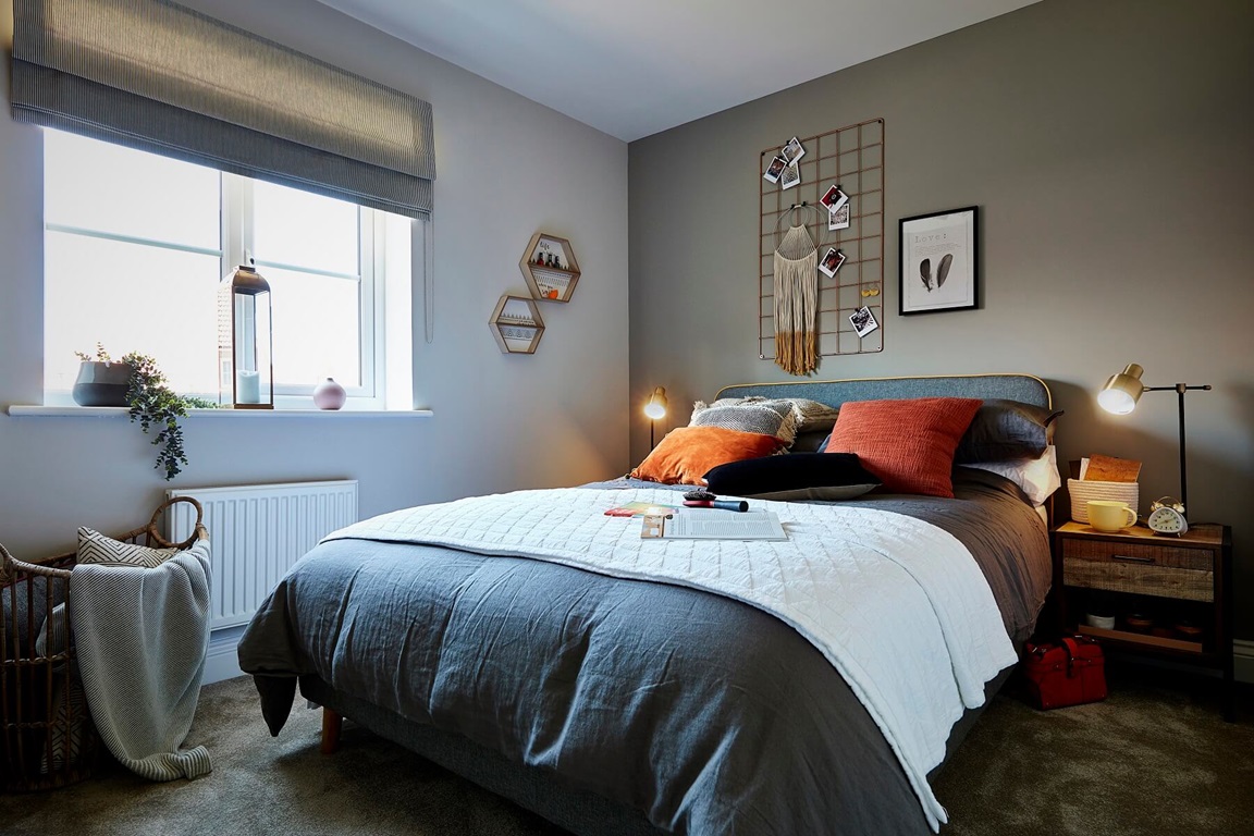 Grey bedroom with orange pillows