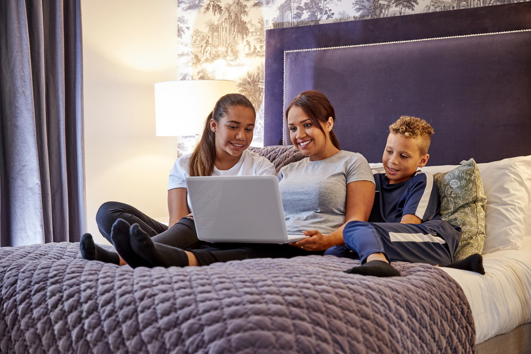 Customers on bed with laptop